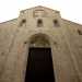 Tripartito da colonne alte e sottili,  caratterizzato dalla presenza di diverse monofore e da un portale in legno inquadrato in una cornice ad arco sormontato da un'apertura a semiluna che doveva conservare un affresco liturgico